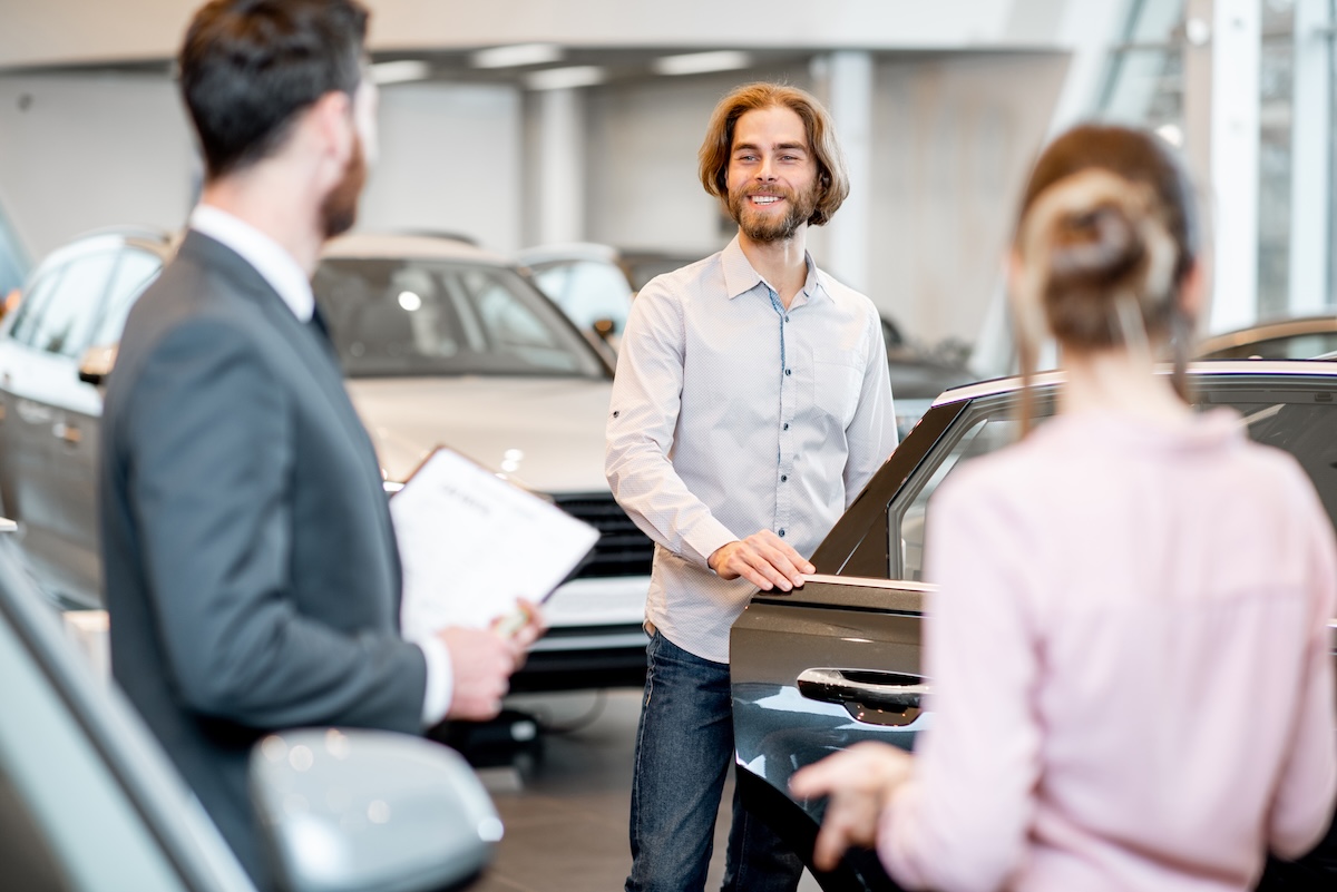 Couple choosing a new car in the showroom